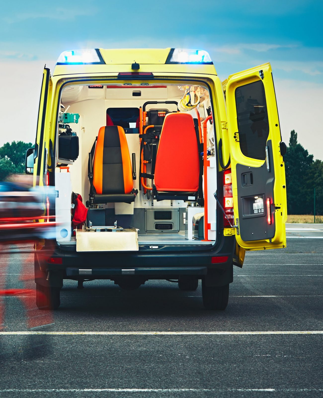 Emergency medical service. Paramedic is pulling stretcher with patient to the ambulance car.